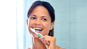 Close-up of a young White woman brushing her teeth in the bathroom
